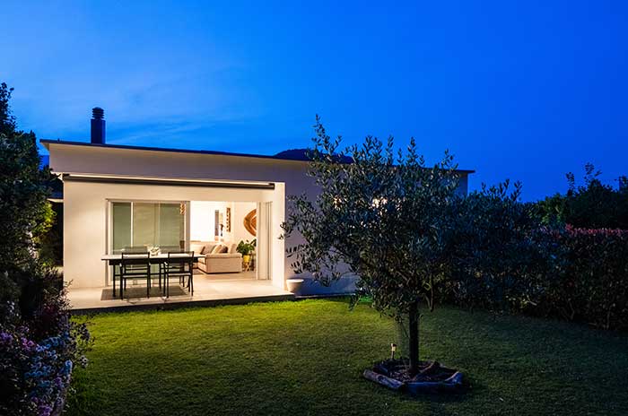 small home at night with porch light on
